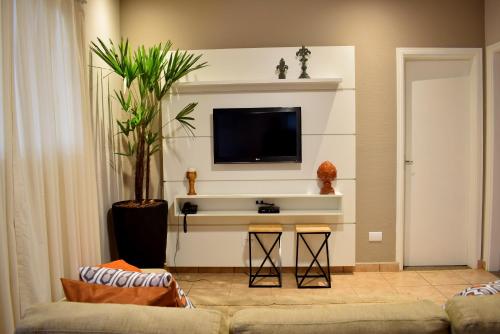 塞拉内格拉O Recanto Pousada的客厅配有沙发和墙上的电视