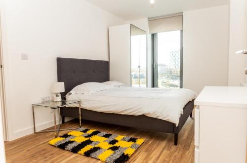 曼彻斯特The Exclusive Apartment的一间卧室配有一张带镜子和桌子的床