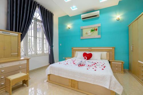 头顿Victory Villa - Sân Vườn - Hồ Bơi - Karaoke - Gần Biển Bãi Sau的一间卧室,床上放着鲜花