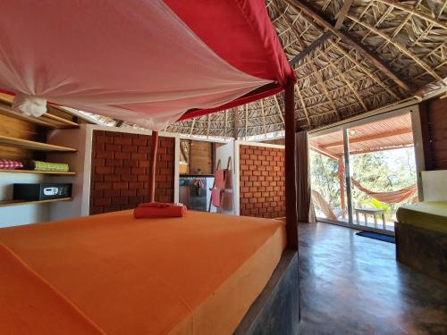 迭戈苏瓦雷斯Ocean Lodge Kite & Windsurf的一间位于房子内的卧室,配有一张橙色的床