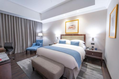 多哈多哈千禧国际酒店的酒店客房带一张大床和一把椅子