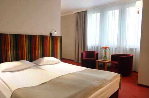 托伦费马尔酒店的酒店客房,配有一张床和两把椅子