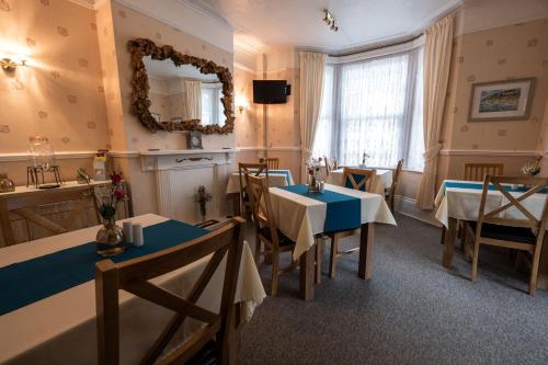 尚克林Appley Lodge的一间设有两张桌子和镜子的用餐室