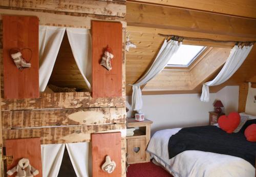 尚佩里L'Eglantine的小木屋内一间卧室,配有一张床