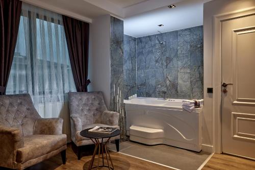 伊斯坦布尔The Bold Hotel的带浴缸、椅子和水槽的浴室