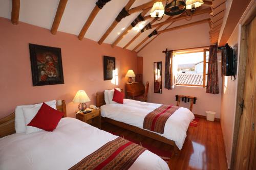 库斯科Hotel & Mirador Los Apus的酒店客房设有两张床和窗户。