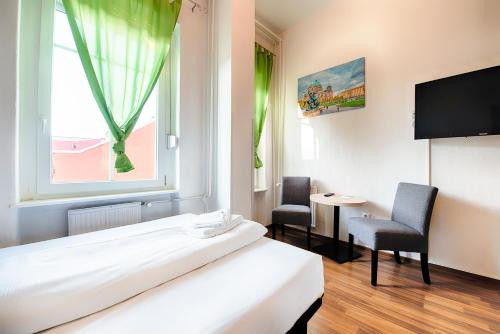 柏林B1酒店的客房设有床、两把椅子和窗户。