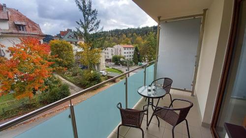 克雷尼察Apartament DOMINO Krynica Zdrój的设有一个配有桌椅并享有美景的阳台。