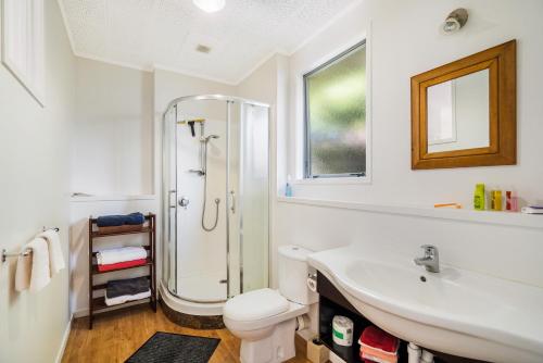 KumeuKumeu Kottage的带淋浴和盥洗盆的白色浴室