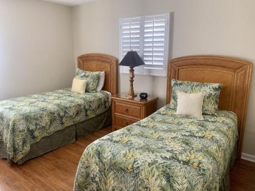 Point O'RocksIsland House Beach Resort 28的一间卧室配有两张床和一盏灯