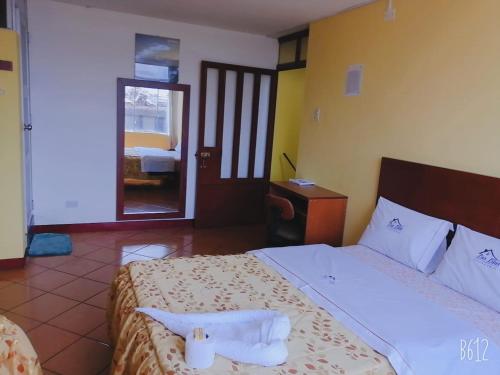 万卡约Hospedaje Las Lilas的酒店客房,设有两张床和镜子