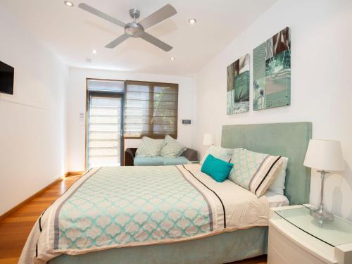 卡尔布拉海滩Illaroo Absolute Beachfront with Spa的一间卧室配有一张床和吊扇