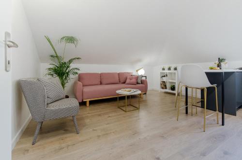 奥米什Inn by the River的客厅配有粉红色的沙发和两把椅子
