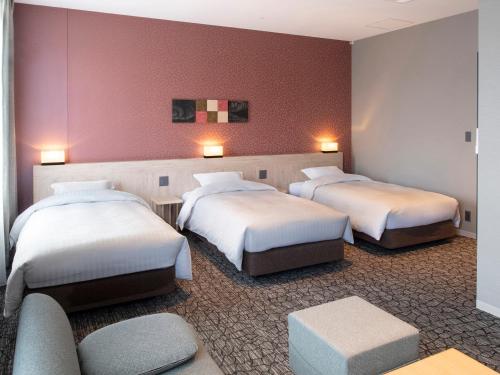 琴平町琴平公园酒店的酒店客房,设有三张床和一张沙发