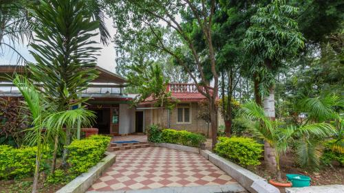 BelūrKSTDC Hotel Mayura Velapuri Belur的前面有庭院的房子