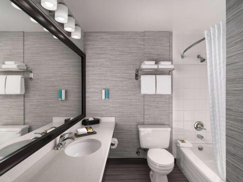 维多利亚贝斯特韦斯特普拉斯卡尔顿广场酒店的浴室配有盥洗盆、卫生间和浴缸。