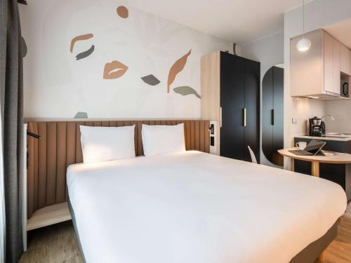 布鲁塞尔Adagio access Brussels Delta的一间带白色大床的卧室和一间厨房
