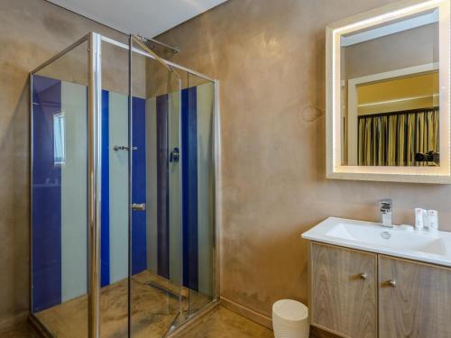 谢丽海滩St Michaels Sands Hotel & Time Share Resort的带淋浴、盥洗盆和镜子的浴室