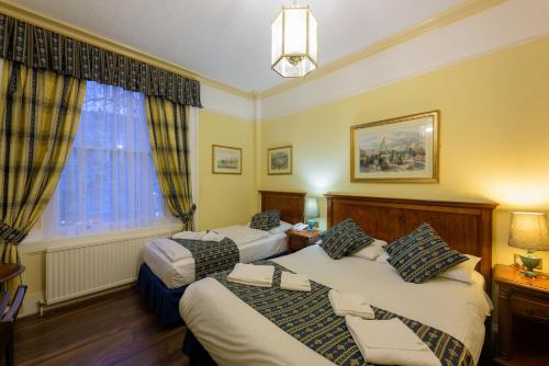 伦敦莎士比亚酒店的酒店客房设有两张床和窗户。