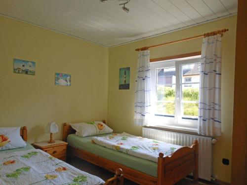 维滕Bungalow-Lerchennest的一间卧室设有两张床和窗户。