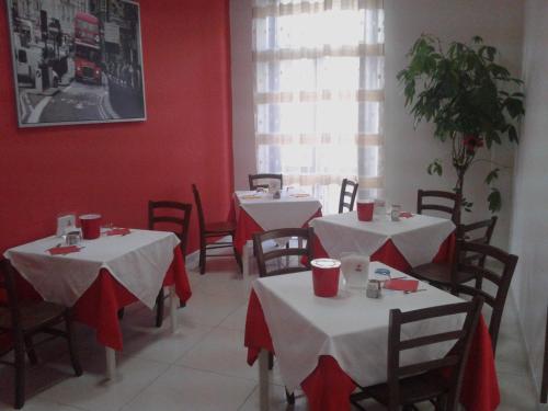 波波利阿尔伯格玛瑞旅馆 的一间用餐室,配有两把桌子和椅子,拥有红色的墙壁