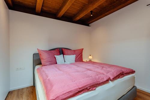 塞费尔德附近赖特Apartment Bergblick的一间卧室配有一张带粉红色毯子和枕头的床。