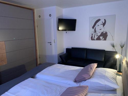 比苏姆Haus-Encore-Wohnung-3的一间卧室配有一张床、一张沙发和一台电视