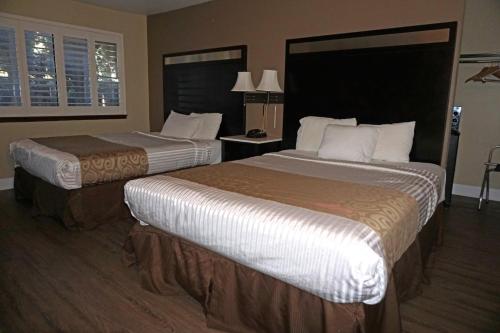 康科德Travelodge by Wyndham Concord的酒店客房设有两张床和窗户。