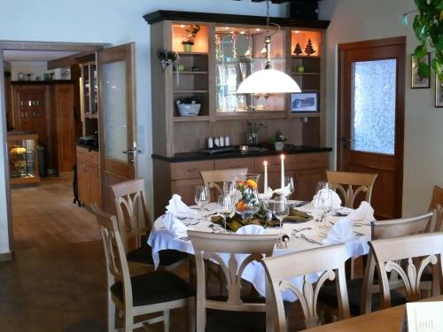 林德伯格Zur Alten Dampfsäge - Gasthaus-Pension Weber的用餐室配有带蜡烛的桌子
