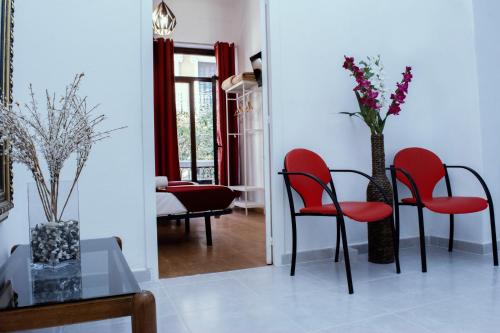 马德里Casa Lemus的客厅配有红色椅子和桌子