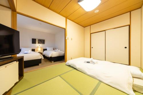 白马村PHOENIX HOTEL by Hakuba Hotel Group的一间卧室设有两张床和大镜子