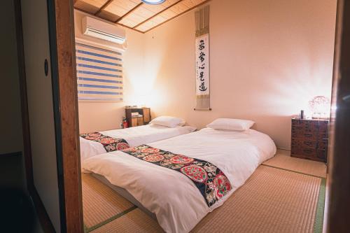 京都茶山旅馆的配有镜子的客房内的两张床