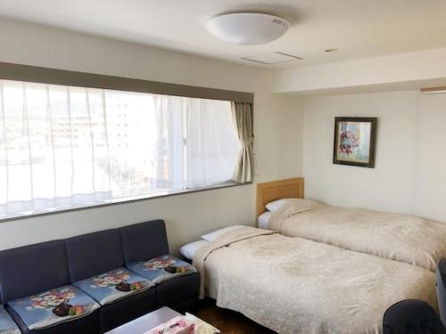 御殿场市御殿场市坦波波富士公寓的一间卧室设有两张床、一张沙发和一个窗口
