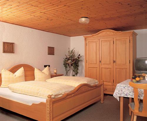 林德伯格Zur Alten Dampfsäge - Gasthaus-Pension Weber的一间卧室配有木床和电视