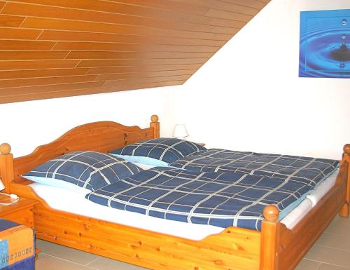 旺格兰Goldene-Linie-4-Deichblick的一间卧室配有一张带蓝色枕头的木床。