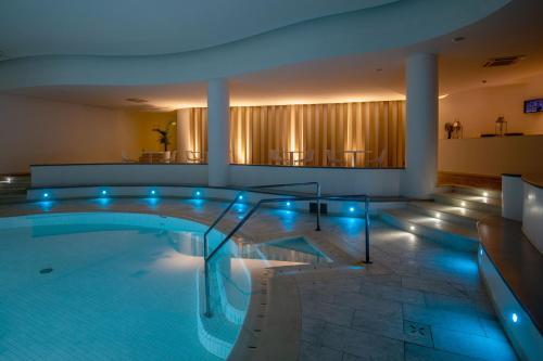 康特港埃尔法鲁酒店及水疗中心 的大楼内带蓝色灯光的大型游泳池