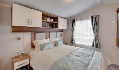 帕Par Sands Coastal Holiday park的一间卧室设有一张大床和一个窗户。