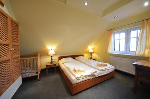格罗斯齐克Lotsenhaus-in-Gross-Zicker-Halbinsel-Moenchgut的一间卧室设有一张床、一个窗口和一张婴儿床