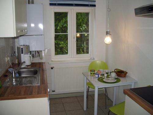BardowickKleines-Ferienhaus-bei-Lueneburg的厨房配有桌子、水槽和窗户