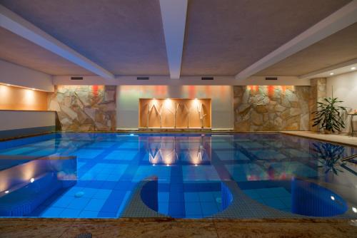 上柯尼希山麓米尔巴赫伯格马特酒店的酒店内有一个蓝色瓷砖的游泳池