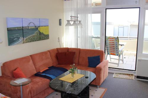 费曼城堡Direkt-am-Suedstrand的带沙发和玻璃桌的客厅
