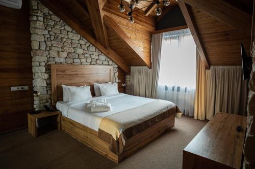 陶里亚蒂Alpen Park的一间卧室设有一张大床和石墙