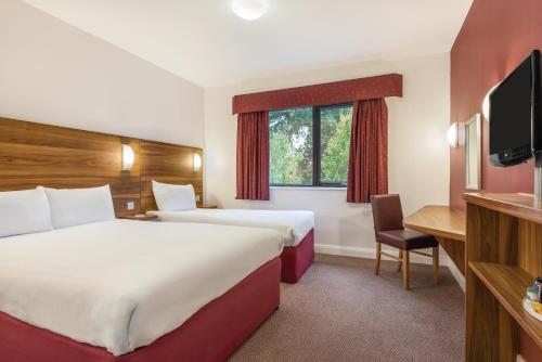 考文垂Days Inn Corley NEC - M6的酒店客房设有两张床和电视。