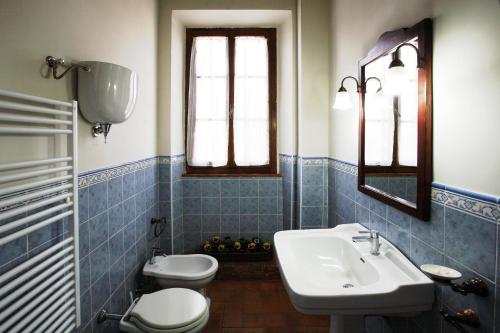 蒙特普尔恰诺斯塔兹奥Agriturismo Le Stringaie的蓝色瓷砖浴室设有水槽和卫生间