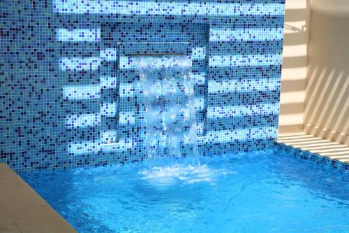 Sumaysimah西麦斯玛阿穆瓦布度假村的游泳池内设有一个喷泉
