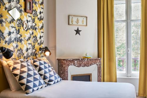 南希Hôtel Stanley by HappyCulture的一间卧室配有一张床和一个壁炉