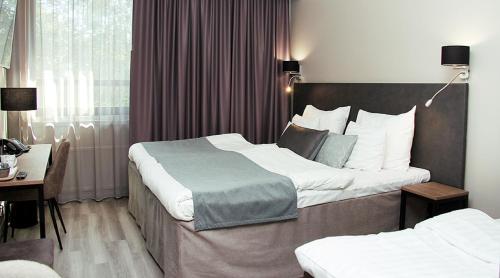 萨洛原始索克斯日卡拉萨罗酒店的酒店客房配有两张床和一张书桌