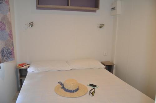 希杰弗朗吉卡Happy Camp mobile homes in Camping Amadria Park Camping Trogir的床上的帽子和太阳镜