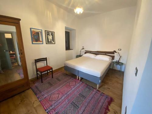 Cantalupo nel SannioB&B Donna Livia的一间卧室配有一张床、一把椅子和地毯