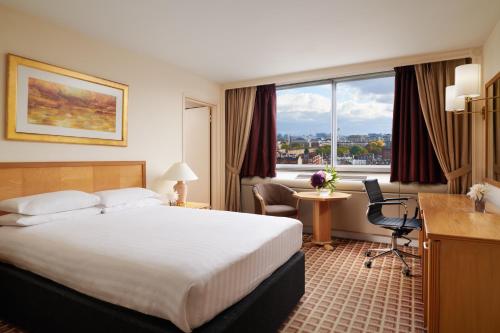 伦敦伦敦肯辛顿国敦塔拉酒店的配有一张床、一张书桌和一扇窗户的酒店客房